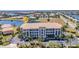 Beautiful waterfront condominium building with lush landscaping, ample parking, and waterfront views at 1349 Aqui Esta Dr # 121, Punta Gorda, FL 33950