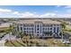 Beautiful three-story building with a tile roof, large balconies, and manicured landscaping and palm trees at 1349 Aqui Esta Dr # 121, Punta Gorda, FL 33950