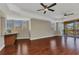 Bright living room with dark wood floors, two ceiling fans, and access to a balcony at 1349 Aqui Esta Dr # 121, Punta Gorda, FL 33950