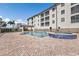 Community pool and jacuzzi surrounded by a large deck and residential building at 1349 Aqui Esta Dr # 121, Punta Gorda, FL 33950