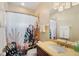Bathroom with a tropical-themed shower curtain and vanity with gold countertops at 14142 Fort Myers Ave, Port Charlotte, FL 33981
