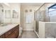 Bright bathroom with walk-in shower and a large vanity with dark wood cabinets at 14142 Fort Myers Ave, Port Charlotte, FL 33981