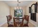 Bright dining room featuring a glass-top table, rattan chairs, and backyard views at 14142 Fort Myers Ave, Port Charlotte, FL 33981