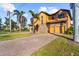 Inviting two-story home with brick driveway, lush lawn, and a three-car garage at 14142 Fort Myers Ave, Port Charlotte, FL 33981