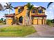 Beautiful two-story house featuring stone accents, a well-manicured lawn, and a three-car garage at 14142 Fort Myers Ave, Port Charlotte, FL 33981