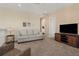 Upstairs living room with neutral carpet, sofa, and television, providing a cozy retreat at 14142 Fort Myers Ave, Port Charlotte, FL 33981