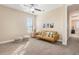 A living room with neutral walls, a window with shutters, yellow sofa, and a ceiling fan at 14142 Fort Myers Ave, Port Charlotte, FL 33981