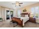 Spacious bedroom featuring a ceiling fan, ensuite bathroom, and access to the home's balcony at 14142 Fort Myers Ave, Port Charlotte, FL 33981