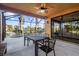 A covered, screened-in patio features an outdoor dining set and views of the spa and waterway at 14142 Fort Myers Ave, Port Charlotte, FL 33981