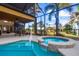 An enclosed pool area features a beautiful pool and spa, along with an outdoor dining area at 14142 Fort Myers Ave, Port Charlotte, FL 33981