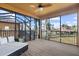 Covered porch with outdoor seating, screened-in views of the lawn, and a ceiling fan at 14142 Fort Myers Ave, Port Charlotte, FL 33981