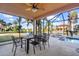 Relaxing patio with dining area and views of the pool, spa, and serene backyard at 14142 Fort Myers Ave, Port Charlotte, FL 33981