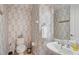 Stylish powder room with patterned wallpaper, pedestal sink, and modern fixtures at 14142 Fort Myers Ave, Port Charlotte, FL 33981