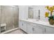 Bright bathroom showcasing a double vanity with a glass shower and white cabinetry at 14224 Heritage Landing Blvd # 923, Punta Gorda, FL 33955