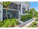 View of a light-blue condo building featuring a screened-in patio and lush landscaping at 14224 Heritage Landing Blvd # 923, Punta Gorda, FL 33955