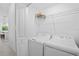 A laundry room with a stacked washer and dryer, storage shelf, and a door at 14224 Heritage Landing Blvd # 923, Punta Gorda, FL 33955