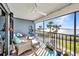 Screened condo balcony with seating offers beautiful ocean views and a peaceful retreat at 1701 Beach Rd # 305, Englewood, FL 34223