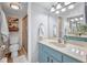 Bathroom with a white countertop, blue vanity, updated mirror, vanity lights, and view to the walk-in shower and toilet at 1701 Beach Rd # 305, Englewood, FL 34223