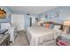Light blue bedroom featuring a king bed with white comforter, coastal decor, and a view to the ensuite bath at 1701 Beach Rd # 305, Englewood, FL 34223