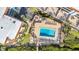 Aerial view of the community swimming pool with lounge chairs, surrounded by lush landscaping and palm trees at 1701 Beach Rd # 305, Englewood, FL 34223