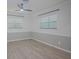 Bedroom with wood-look floors, two windows, and neutral paint scheme at 1795 Elinor Pl, Englewood, FL 34223