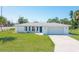 Charming single-story home with a well-maintained lawn and a classic blue front door at 1795 Elinor Pl, Englewood, FL 34223