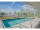 Screened-in pool with patio and lush landscaping creates a private backyard oasis at 1795 Elinor Pl, Englewood, FL 34223