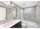 Stylish bathroom with a sleek vanity, elegant tile, and a glass-enclosed shower over a bathtub at 18263 Ohara Dr, Port Charlotte, FL 33948