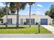 Charming single-story home with a well-maintained lawn, blue shutters, and palm trees at 18263 Ohara Dr, Port Charlotte, FL 33948