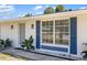 Charming home featuring white exterior, blue shutters, decorative screen door, and manicured tropical plants at 18263 Ohara Dr, Port Charlotte, FL 33948