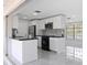 Modern kitchen featuring sleek white cabinetry, black countertops, stainless steel appliances and breakfast bar at 18263 Ohara Dr, Port Charlotte, FL 33948