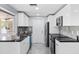 Modern kitchen featuring sleek white cabinetry, black countertops, and stainless steel appliances at 18263 Ohara Dr, Port Charlotte, FL 33948
