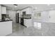 Bright kitchen with stainless steel appliances, black countertops, and neutral walls with tile flooring at 18263 Ohara Dr, Port Charlotte, FL 33948