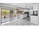 Bright, modern kitchen featuring sleek white cabinets, black countertops, and a screened-in patio view at 18263 Ohara Dr, Port Charlotte, FL 33948