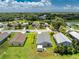 A well-maintained single-Gathering home, nestled within a community, boasts lush backyard landscaping, and mature trees at 20016 Sancraft Ave, Port Charlotte, FL 33954
