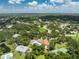 Community aerial view highlights pool, tennis court, surrounded by lush landscape, neighborhood homes at 20016 Sancraft Ave, Port Charlotte, FL 33954