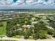 Scenic aerial view showcases a community area, featuring a pool and tennis court surrounded by mature trees and landscaping at 20016 Sancraft Ave, Port Charlotte, FL 33954