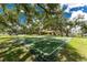 Outdoor basketball court surrounded by mature trees and green grass, perfect for sports and recreation at 20016 Sancraft Ave, Port Charlotte, FL 33954