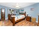 Cozy bedroom featuring hardwood floors, blue walls, and a comfortable wood-framed bed at 20016 Sancraft Ave, Port Charlotte, FL 33954