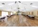 Spacious meeting room with tables, chairs, wood floors, and ceiling fans offers a comfortable gathering space at 20016 Sancraft Ave, Port Charlotte, FL 33954