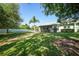 Large, green backyard with a well-maintained lawn, a palm tree, and a view of the home at 2024 Royal Tern Cir, Punta Gorda, FL 33983