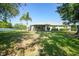 Expansive backyard with lush lawn, mature trees, and view of the home's exterior at 2024 Royal Tern Cir, Punta Gorda, FL 33983