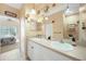 Bright bathroom with dual sinks, decorative lighting, and a view into the bedroom at 2024 Royal Tern Cir, Punta Gorda, FL 33983