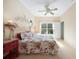 Well-lit bedroom featuring a ceiling fan, floral bedding, and a view of the backyard at 2024 Royal Tern Cir, Punta Gorda, FL 33983
