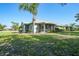 Charming home featuring a screened lanai, lush landscaping, and a well-maintained lawn under a sunny sky at 2024 Royal Tern Cir, Punta Gorda, FL 33983