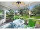 Screened lanai with seating and view of the landscaped backyard and mature trees at 2024 Royal Tern Cir, Punta Gorda, FL 33983