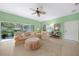 Bright living room featuring a ceiling fan, neutral tile floors, and sliding doors to the outside patio at 2024 Royal Tern Cir, Punta Gorda, FL 33983