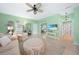 Cozy living room with a ceiling fan, neutral tile floors, and a view into the bathroom at 2024 Royal Tern Cir, Punta Gorda, FL 33983