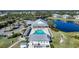 Aerial view showcasing the community pool, clubhouse, and well-maintained landscaping by a pond at 2024 Royal Tern Cir, Punta Gorda, FL 33983