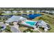 Aerial view of the community pool with lounge chairs, clubhouse, and a serene pond at 2024 Royal Tern Cir, Punta Gorda, FL 33983